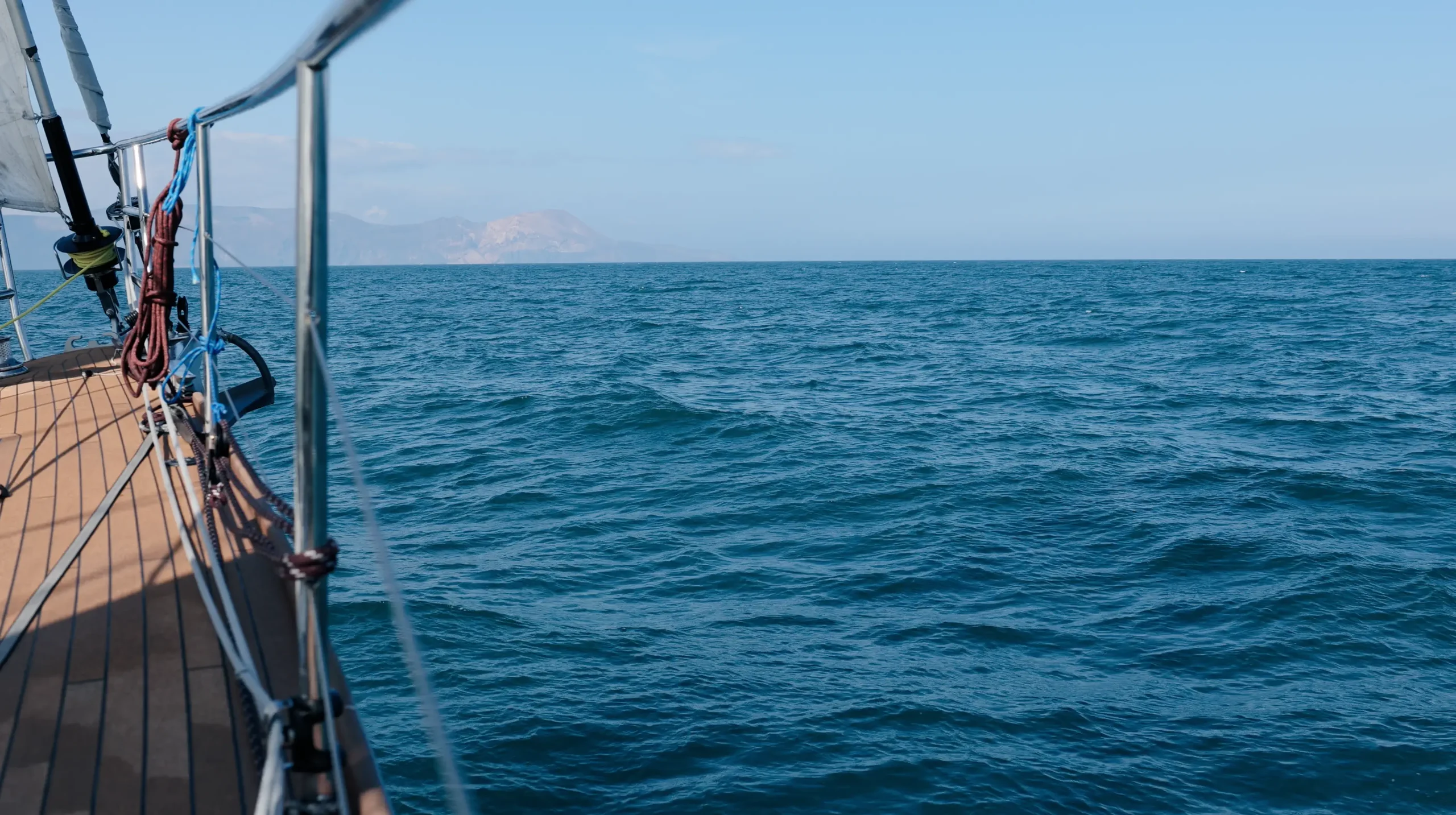 Blick auf den ruhigen blauen Ozean von einem Bootsdeck aus, das die Mission der ruhigen Erkundung umarmt.