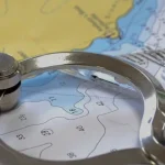 Yachtmaster-Theorie mit einem Trennblatt und Bleistift auf einer Seekarte.